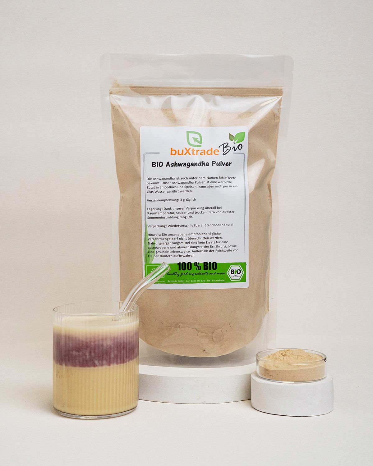 Beutel, Glas mit Flüssigkeit, Schale mit Pulver. Aufschrift: buXtrade Bio Ashwagandha Pulver. Bio-Siegel.