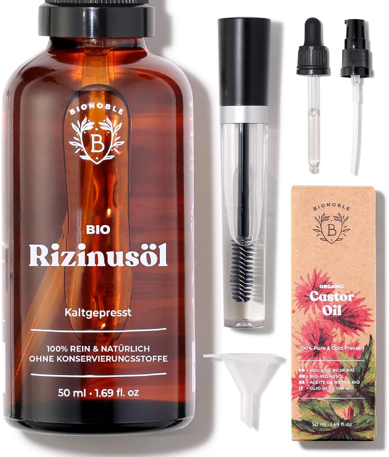 Braune Glasflasche "Bionoble Bio Rizinusöl". Mascara-Bürste, Trichter, Pipette. Karton "Castor Oil". Text: "Kaltgepresst".