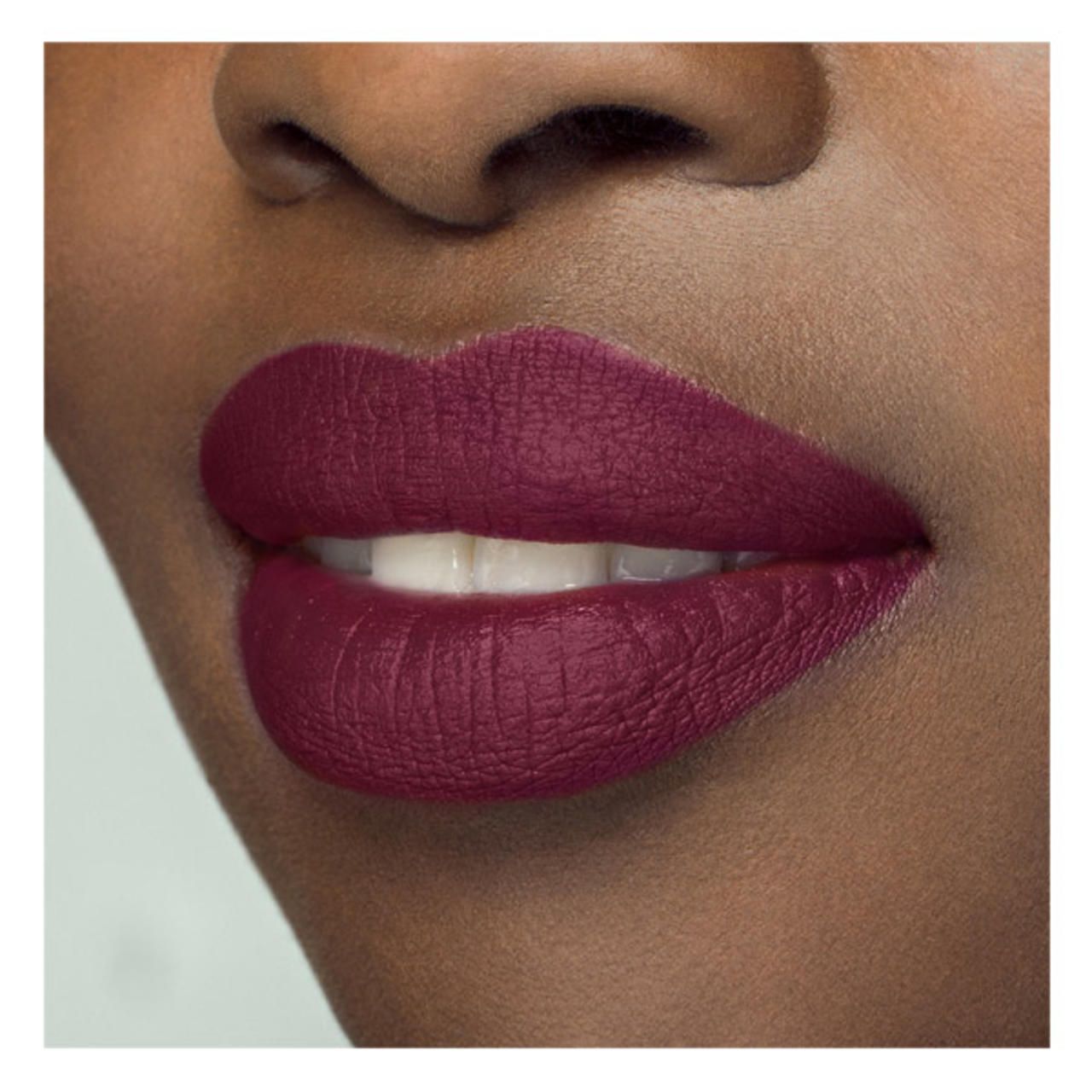 Nahaufnahme von Lippen mit mattem, burgunderrotem Lippenstift. Die Lippen sind geöffnet.