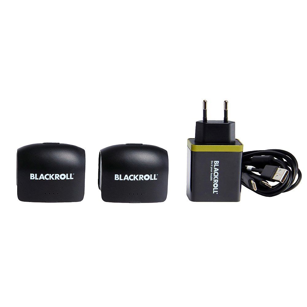 Zwei BLACKROLL Kompressionsstiefel-Module, ein Netzteil und ein Ladekabel.