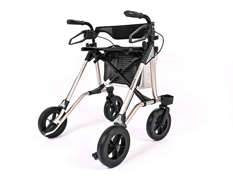 Rollator mit vier Rädern, schwarzem Korb und Sitzfläche. Das Gestell ist silberfarben. Der Rollator hat den Schriftzug TAiMA.
