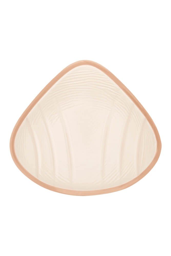 Brustprothese, Innenseite. Beige, mit geriffelter Oberfläche und einem braunen Rand.