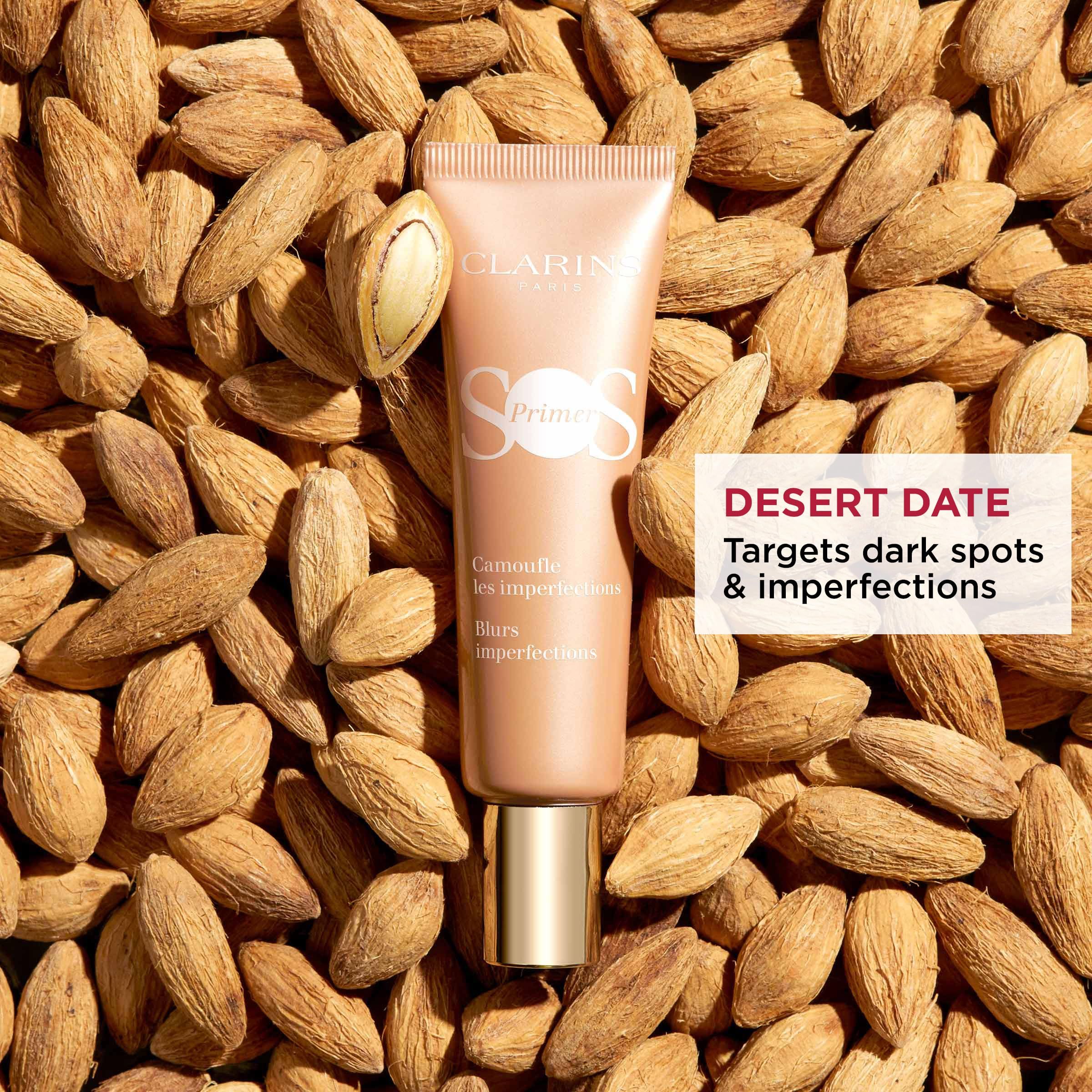 Tube CLARINS SOS Primer Peach auf Mandeln. Text: Desert Date, Targets dark spots & imperfections.