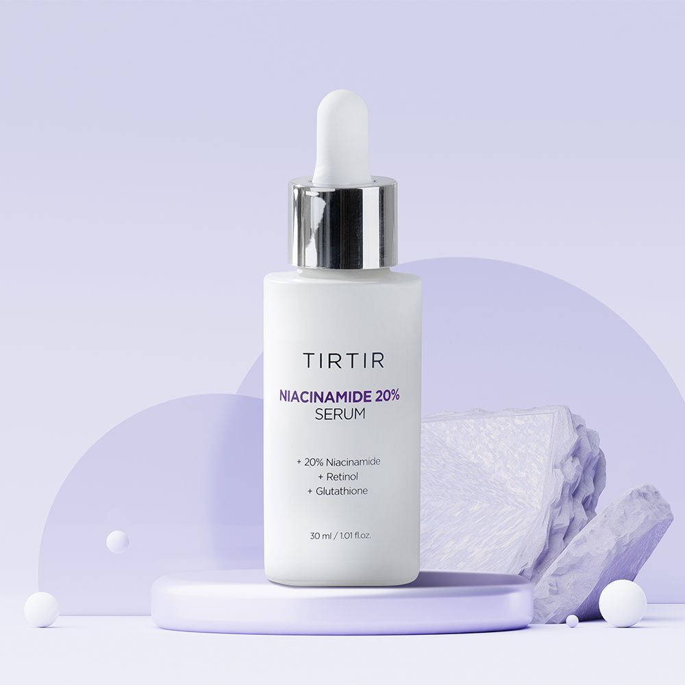 Weiße Flasche mit Serum. Aufschrift: TIR TIR Niacinamide 20% Serum. Mit Pipette. Auf Podest und Steinen platziert.