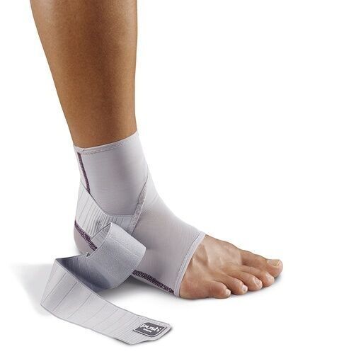 Knöchelbandage, grau-weiß. Bandage neben Fuß. Klettverschlüsse und Verstärkungen sichtbar. Logo 'Push' auf Bandage.