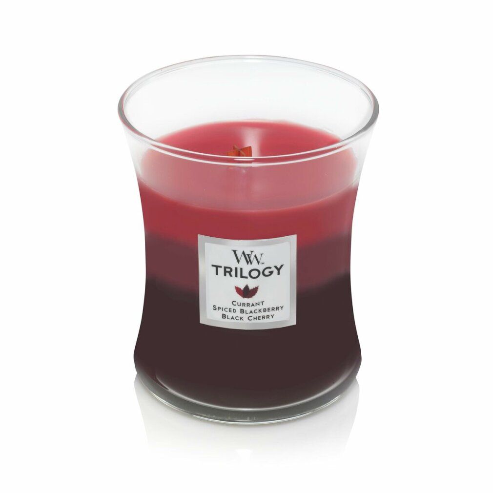 Dreifarbige Kerze im Glas. Label mit 'WW Trilogy'. Farben: Rot, Pink, Dunkelrot. Holzdocht sichtbar.