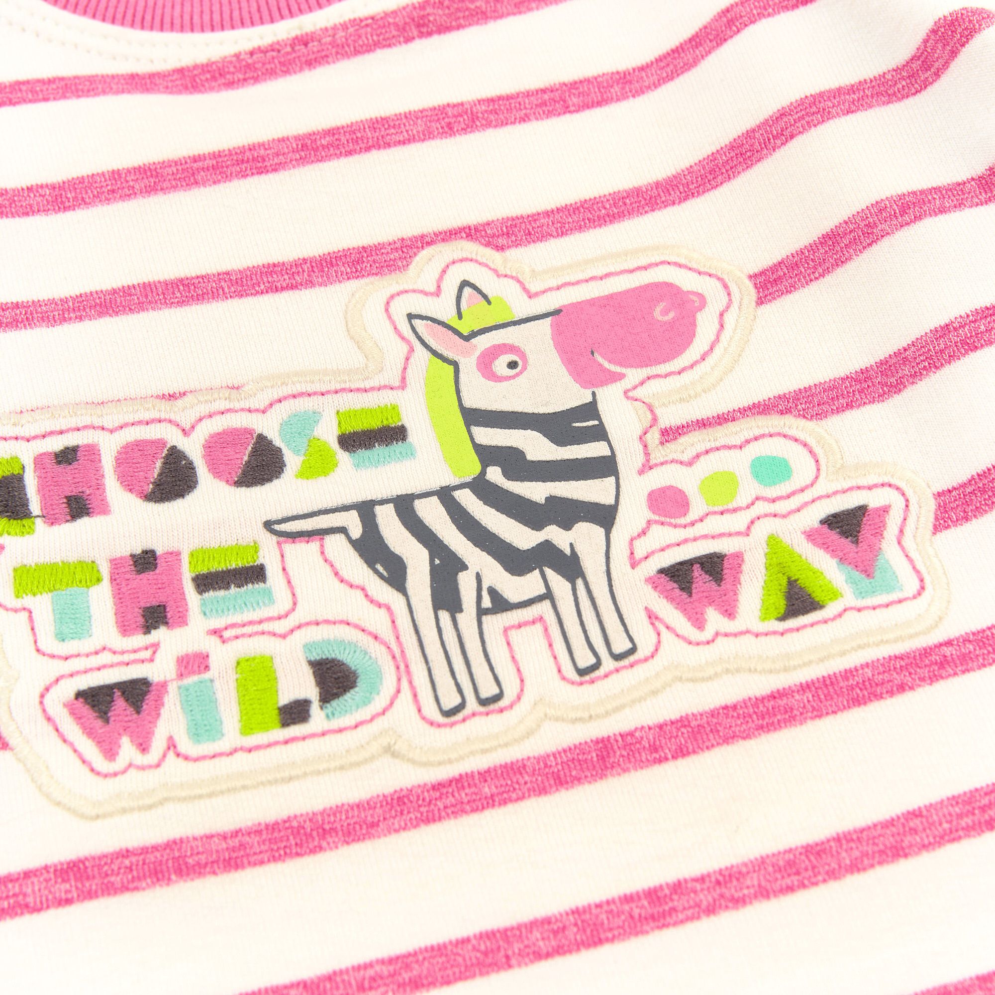 Nahaufnahme des Zebra-Aufnähers auf dem rosa gestreiften Baby-Sweatshirt. Mit Schriftzug.