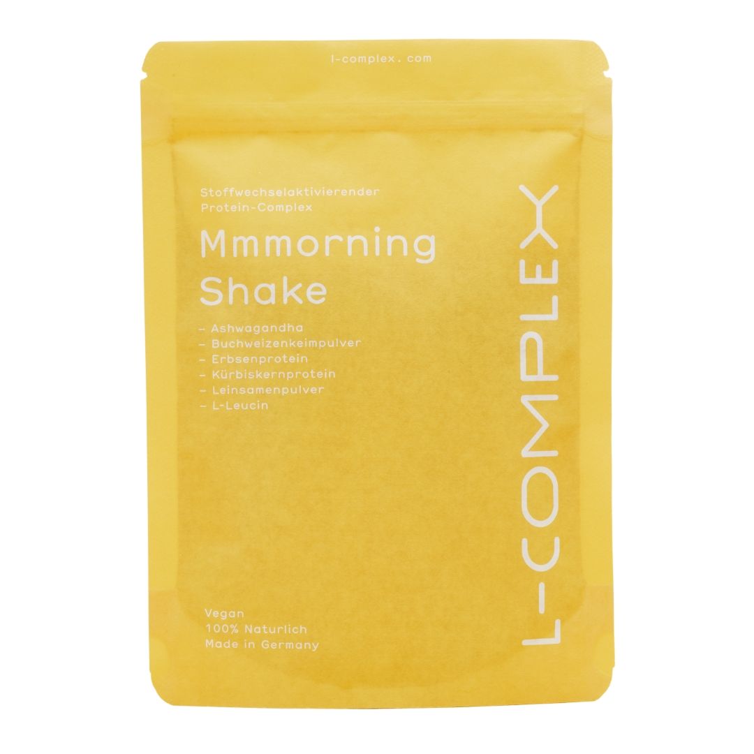 Gelbe Verpackung mit Aufschrift "Mmmorning Shake" und "L-COMPLEX". Enthält Zutaten wie Buchweizenprotein und L-Leucin. Vegan, 100% natürlich, Made in Germany.