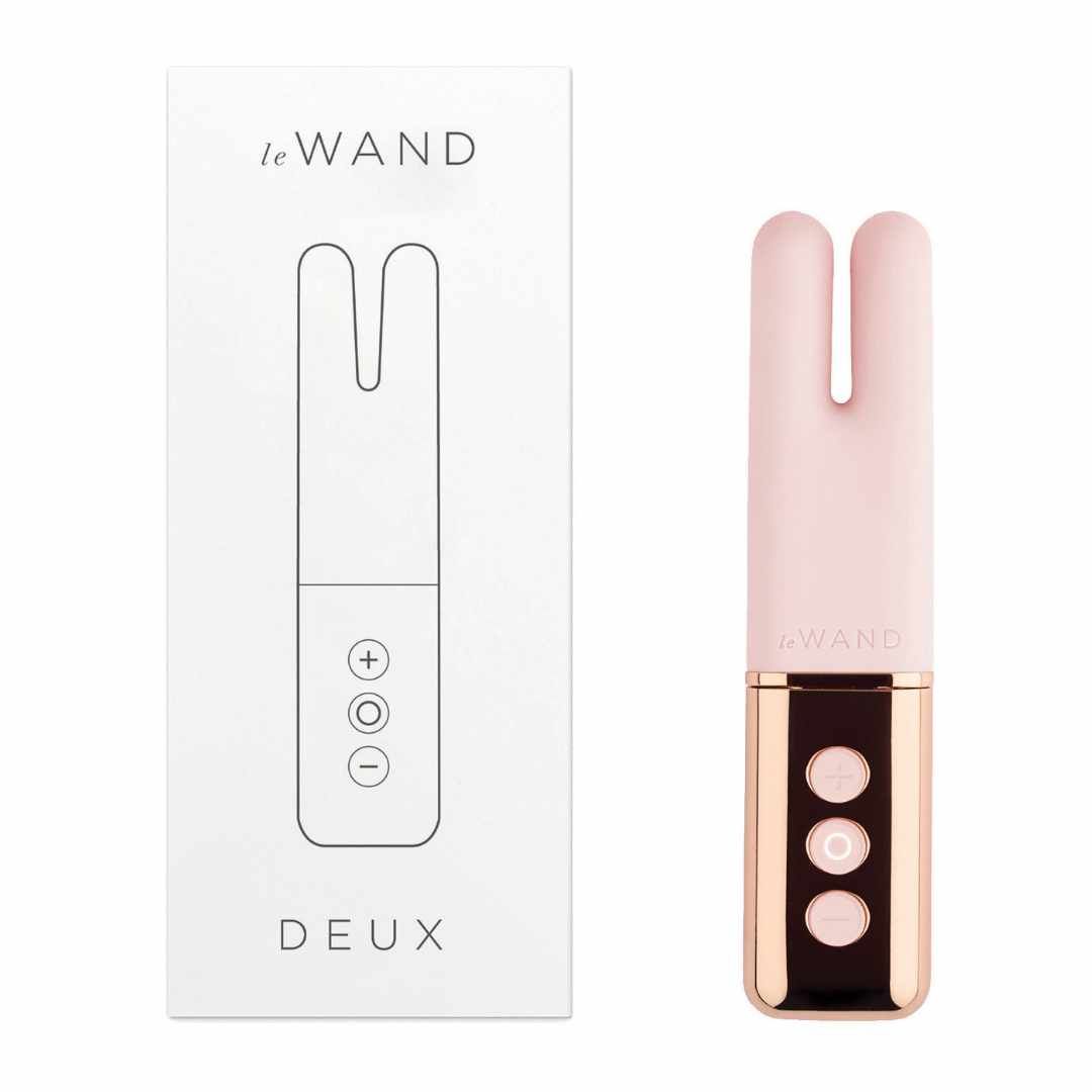 Rosa Vibrator neben Verpackung. Verpackung mit Produktzeichnung und Text: Le Wand, Deux.