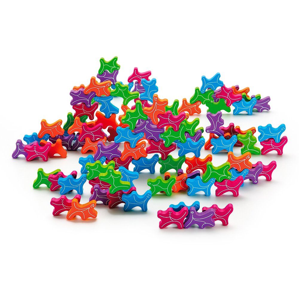 Bunte Holzfiguren, Stapelgeister, in verschiedenen Farben. Viele Figuren liegen ungeordnet auf weißem Hintergrund.