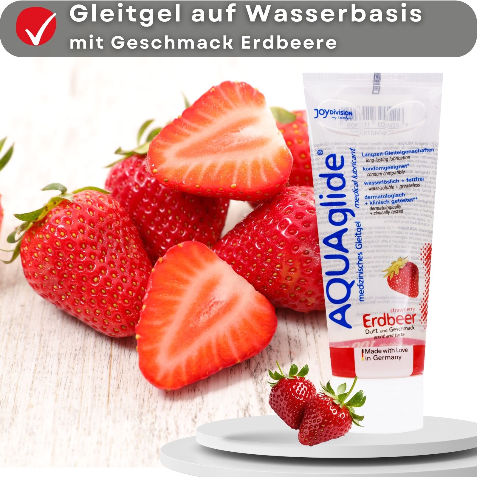 Gleitgel-Tube AQUAglide Erdbeer. Auf Wasserbasis, Erdbeer-Geschmack. Erdbeeren auf Holzuntergrund.