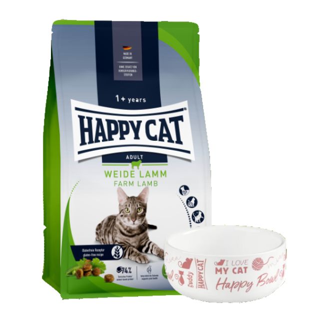 Packung Happy Cat Adult Weide-Lamm Katzenfutter und Futternapf. Aufschrift: Happy Cat, Weide Lamm, 1+ Jahre. Napf mit Aufschrift: I love my cat.