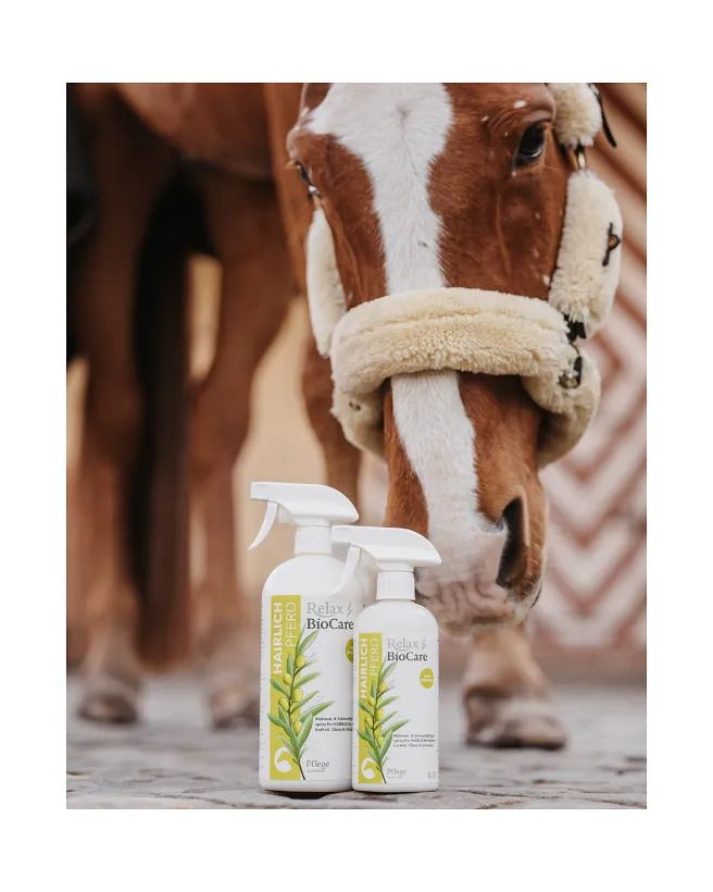 Zwei Relax Biocare Hairlich Sprühflaschen vor einem Pferd. Aufschrift: Mähnen- & Schweifpflegespray für Ihr Pferd. Olivenzweig-Illustration.