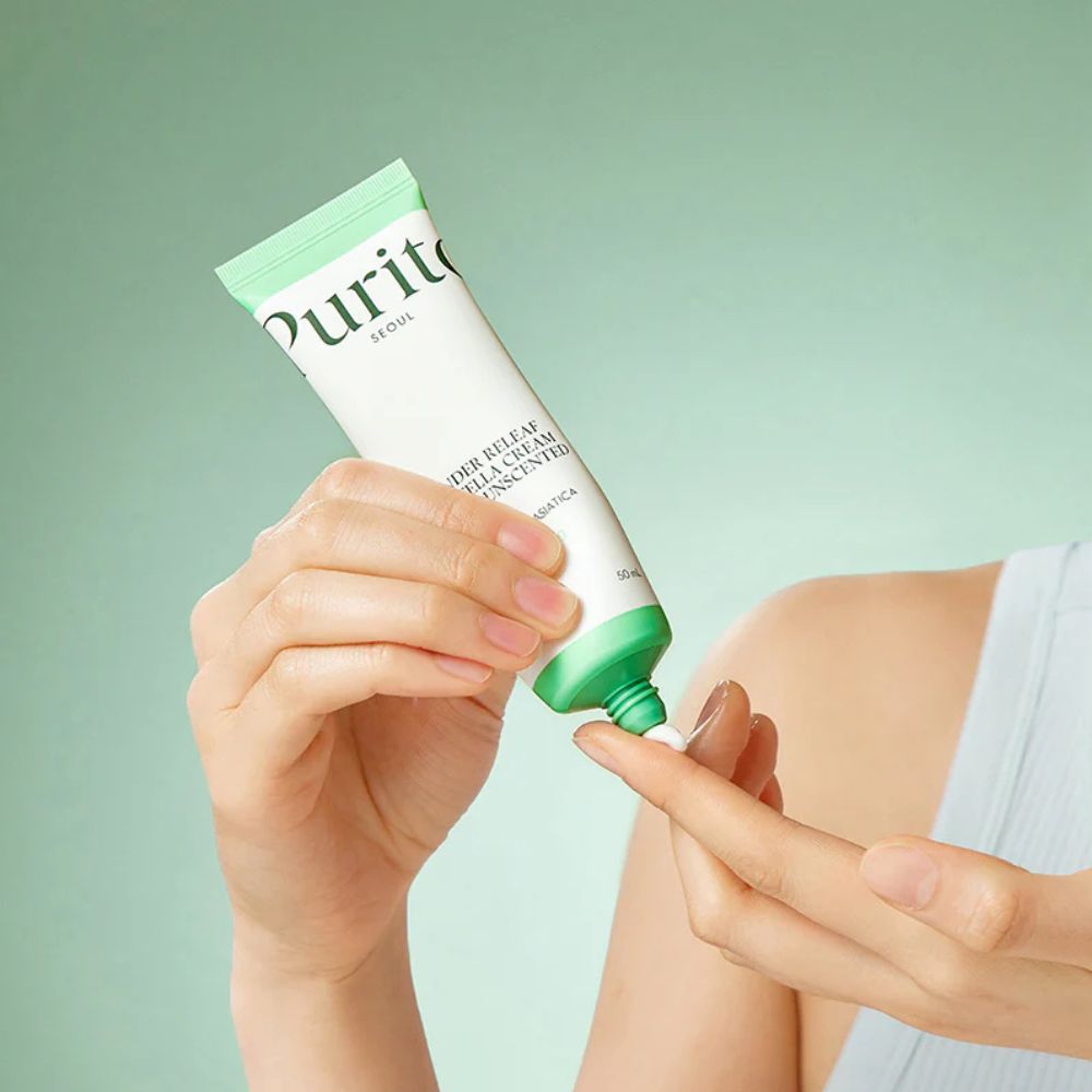 Hand trägt PURITO Wonder Releaf Centella Cream Unscented auf den Finger auf.