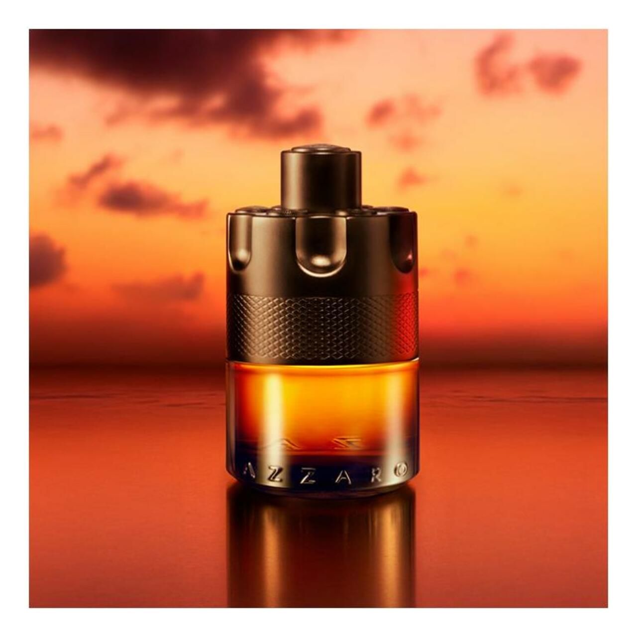 Schwarze Flasche mit brauner Flüssigkeit. Hintergrund: Sonnenuntergang. Aufschrift: Azzaro.