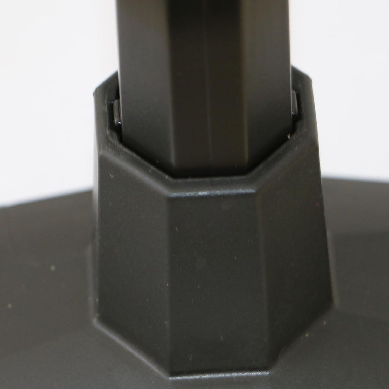 Nahaufnahme der Basis einer schwarzen Push-up-Bar. Die Basis hat eine sechseckige Form und ist mit dem Stützteil verbunden.