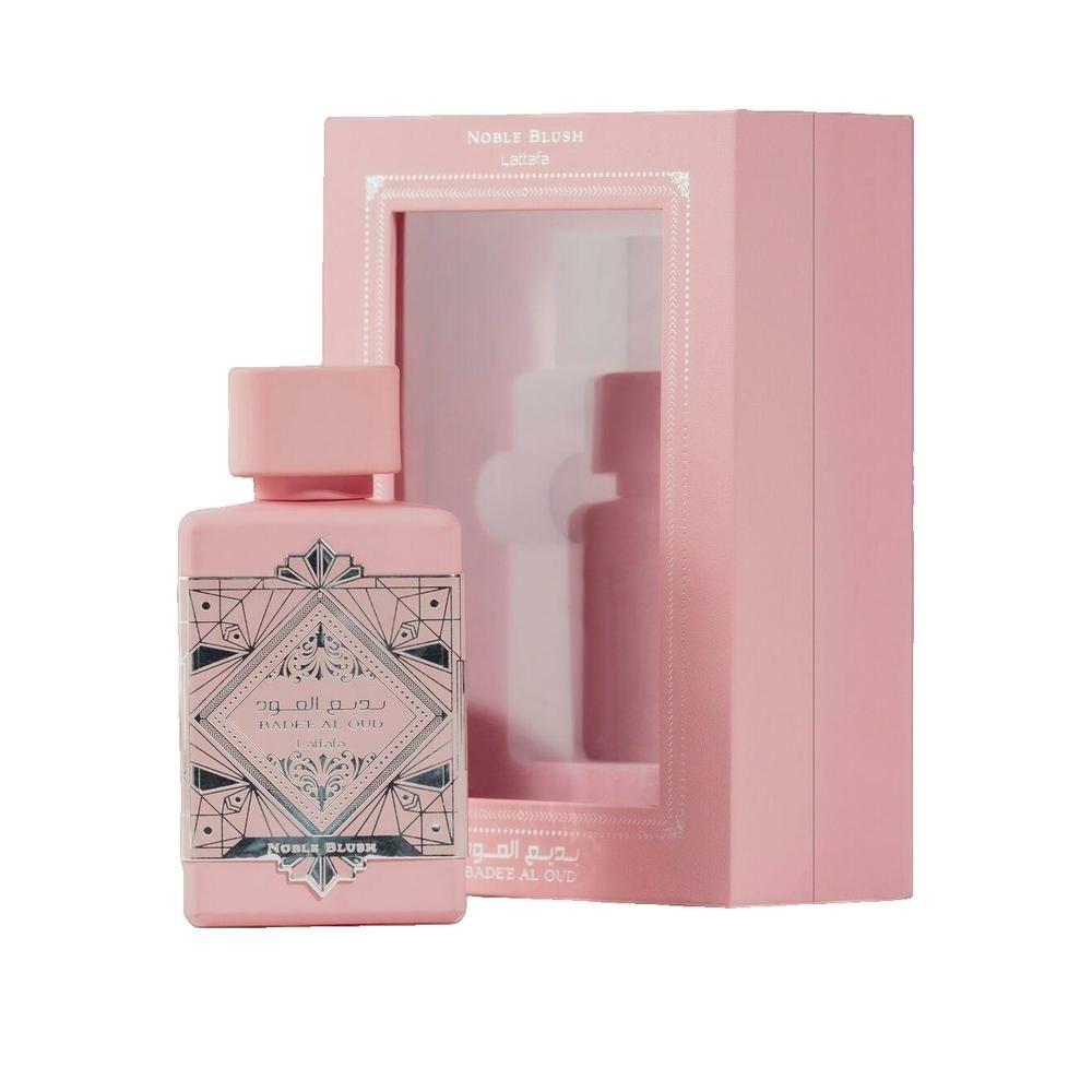 Rosa Flakon mit rechteckigem Etikett und rosa Verpackung. Auf dem Etikett arabische Schriftzeichen und „Noble Blush“. Verpackung mit Sichtfenster.