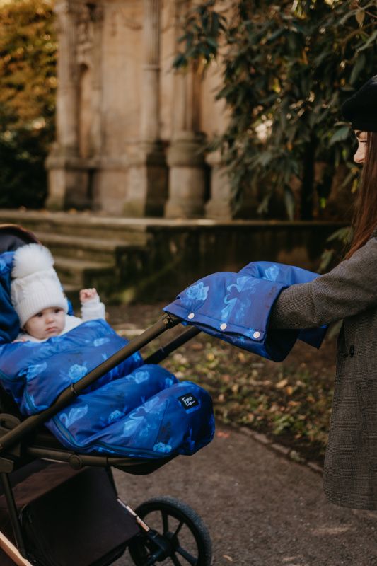 Blauer Fußsack mit Blumenmuster für Kinderwagen. Ein Baby sitzt darin.