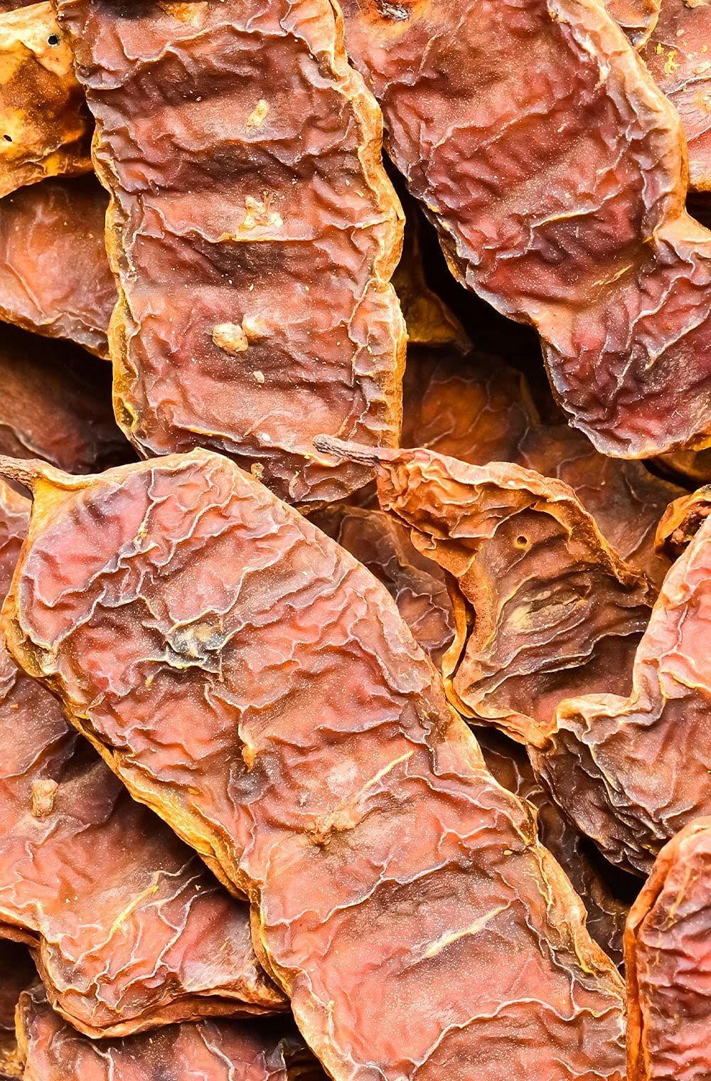 Nahaufnahme von getrockneten, braunen Shikakai-Früchten. Die Früchte haben eine runzlige Oberfläche.