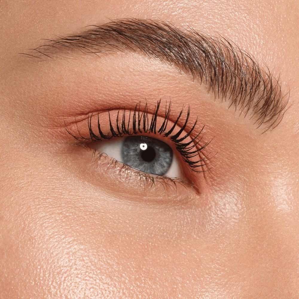 Nahaufnahme eines Auges. Rosa Lidschatten, schwarze Wimperntusche. Blaue Augen.
