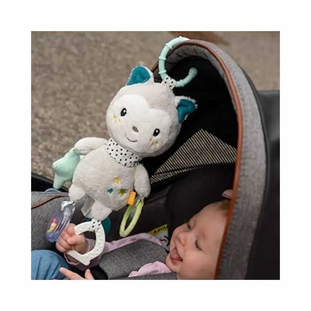 Baby im Kinderwagen mit grauem Kuscheltier. Kuscheltier hat blaue Ohren, gepunkteten Schal, Stern, Spiegel und Rassel.
