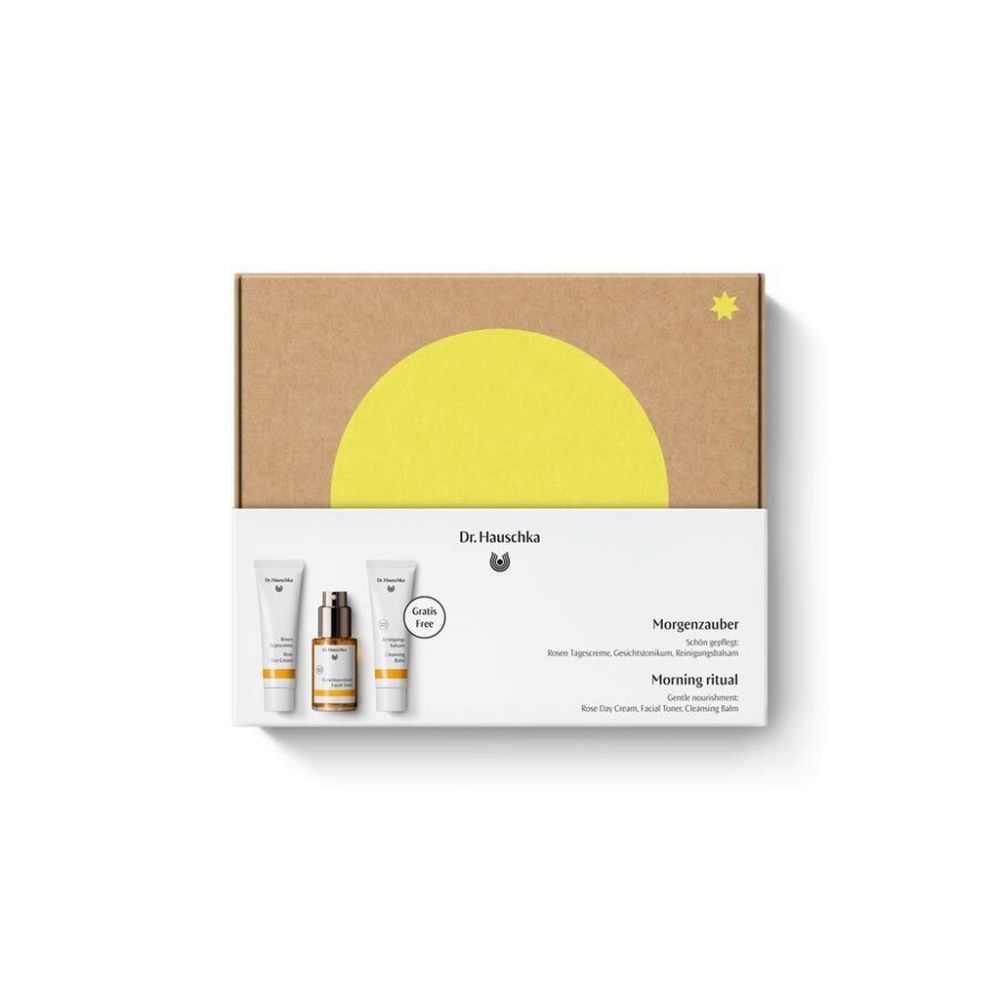 Geschenkset mit Kosmetikprodukten. Karton mit gelber Sonne und Stern. Produkte in weißen Tuben und Flasche.