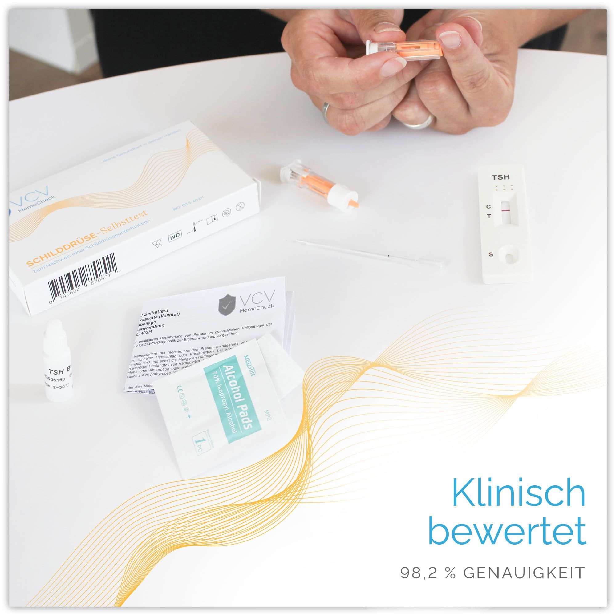 Verschiedene Testkomponenten auf einem Tisch. VCV HomeCheck-Verpackung, Teststreifen, Pipette, Alkoholtupfer und Anweisungen.