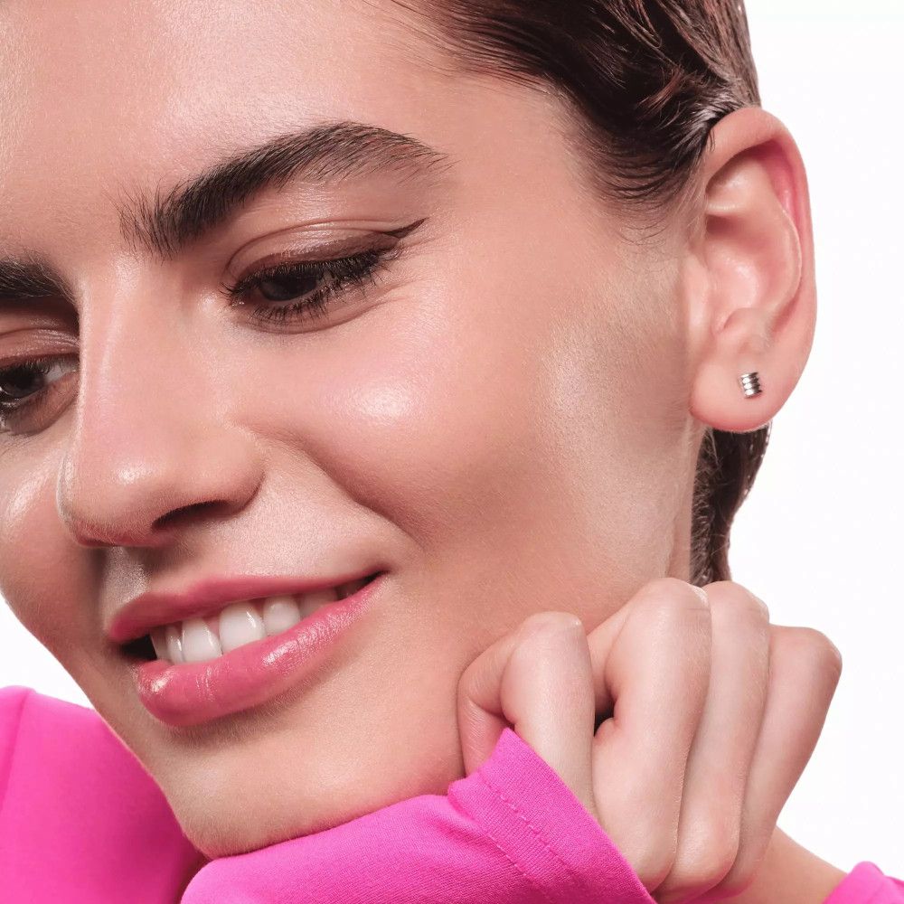 Frau mit pinkem Oberteil, Eyeliner am Auge.