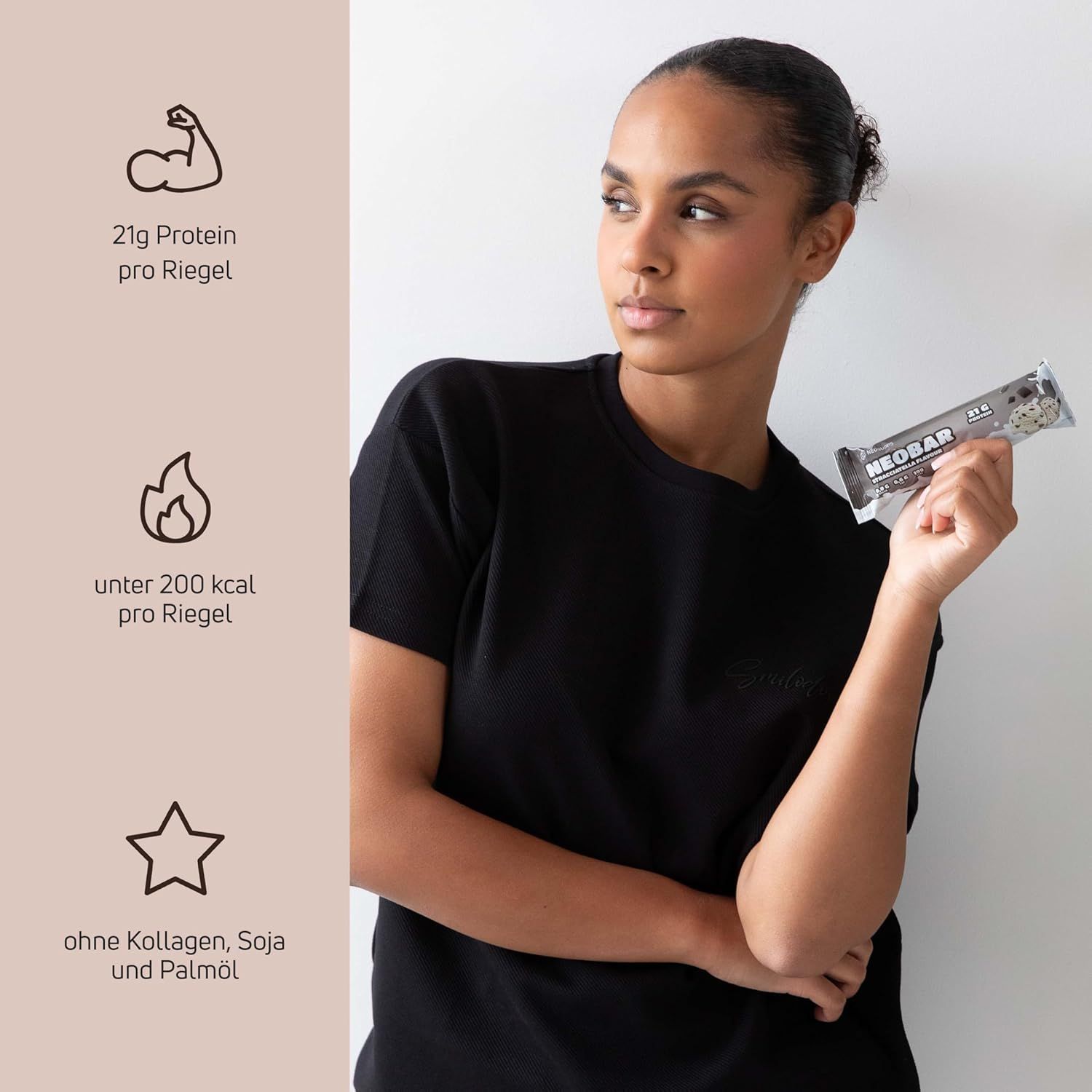 Frau hält einen Proteinriegel. Auf dem Riegel steht „NEOBAR“. Daneben Icons mit Text: 21g Protein, unter 200 kcal, ohne Kollagen, Soja und Palmöl.