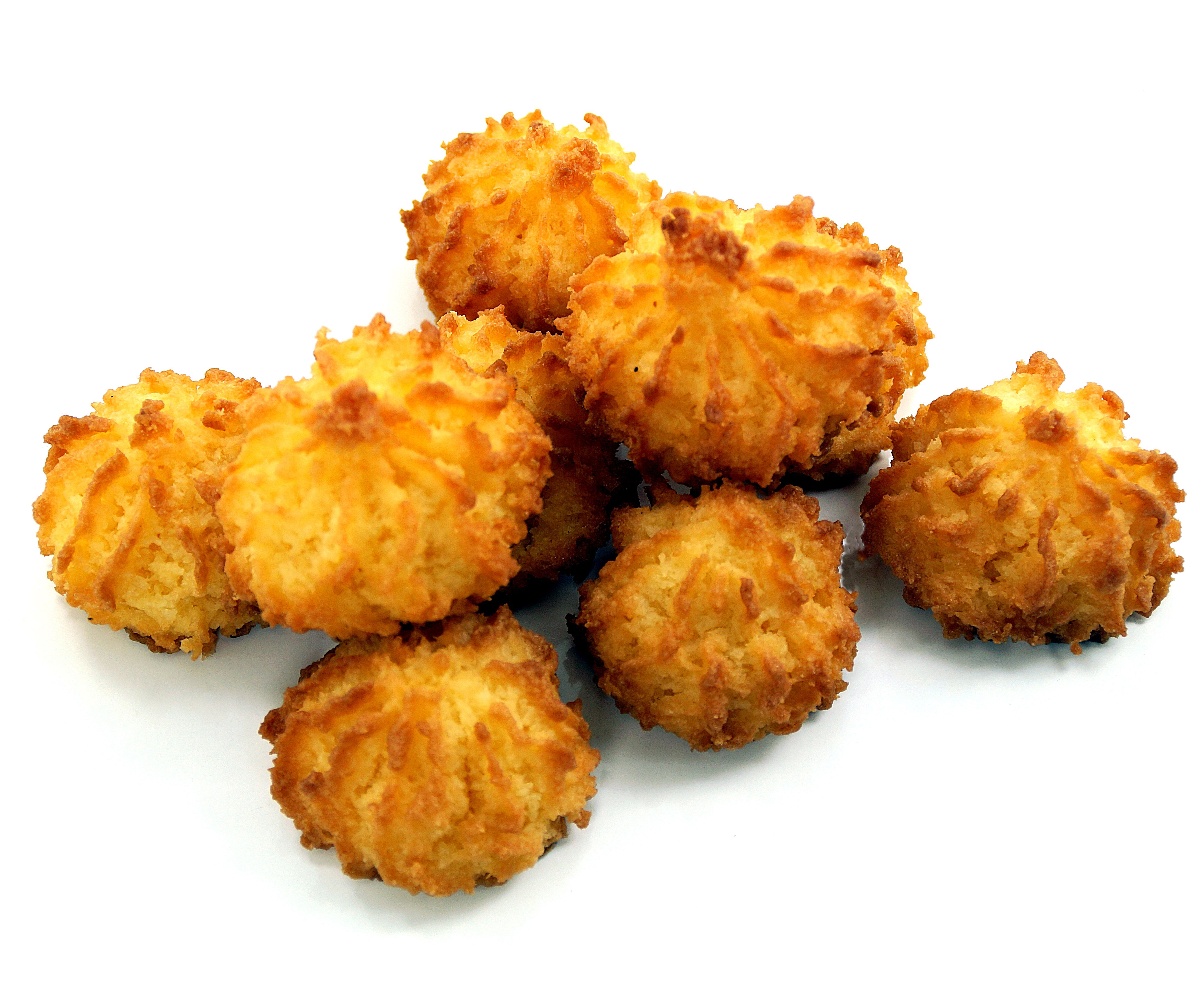 Haufen Kokosmakronen. Goldbraune, unregelmäßige Form. Auf weißem Hintergrund.