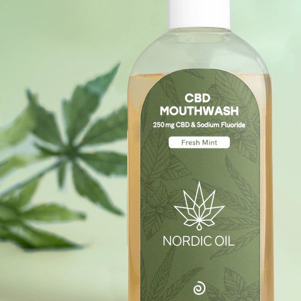 Nahaufnahme einer Flasche mit grünem Etikett. Etikett mit Text: CBD Mouthwash, Nordic Oil, 250mg CBD & Sodium Fluoride.