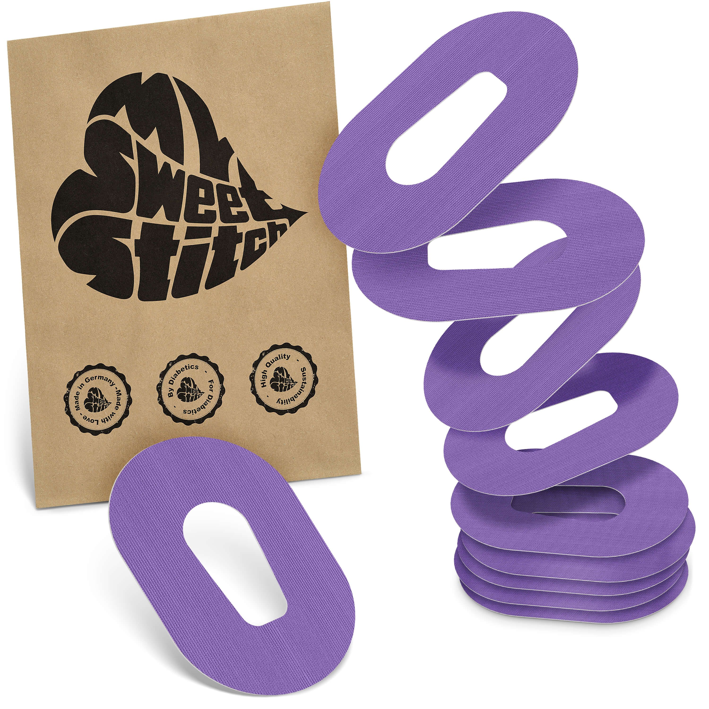 Fixierpflaster, lila, mit Aussparung. Mehrere Pflaster und eine braune Verpackung mit Logo.