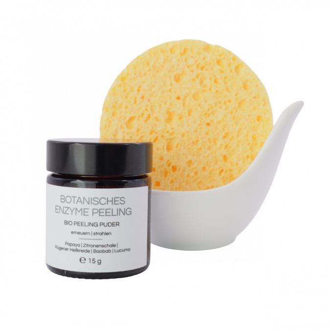 Braunes Glas mit schwarzem Deckel und Etikett. Gelber Schwamm in weißer Schale. Text: Botanisches Enzym Peeling, Bio Peeling Puder, e 15 g.