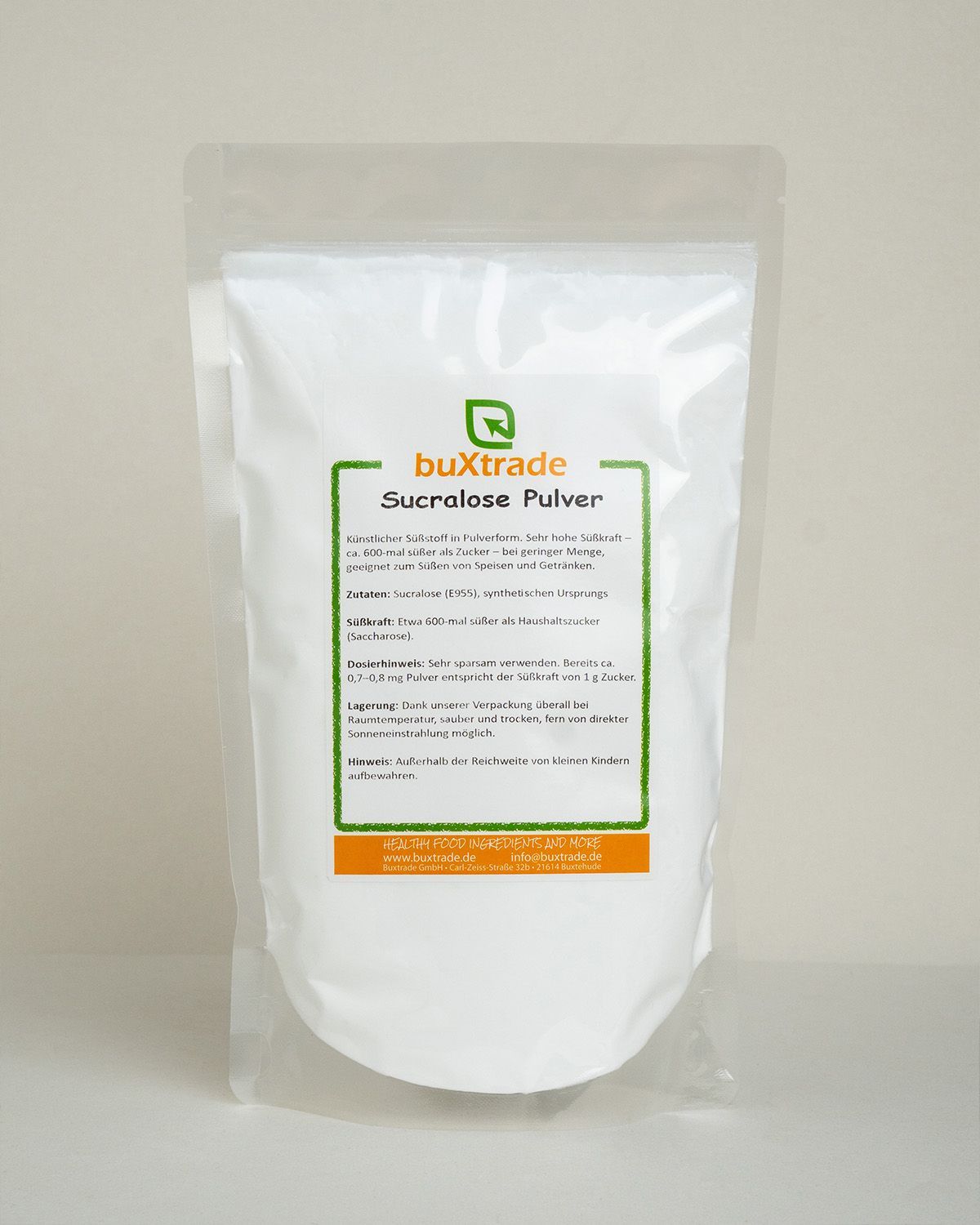 Buxtrade Sucralose Pulver in einem weißen Standbodenbeutel, daneben ein Glas und ein Holzlöffel.