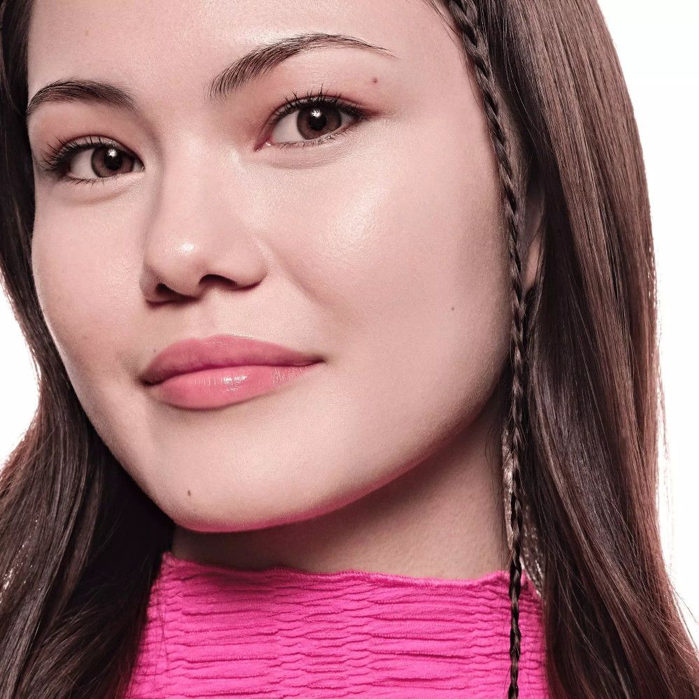 Porträt einer Frau mit Make-up. Hautton: ebenmäßig. Lippen: rosa. Haare: braun, geflochten.