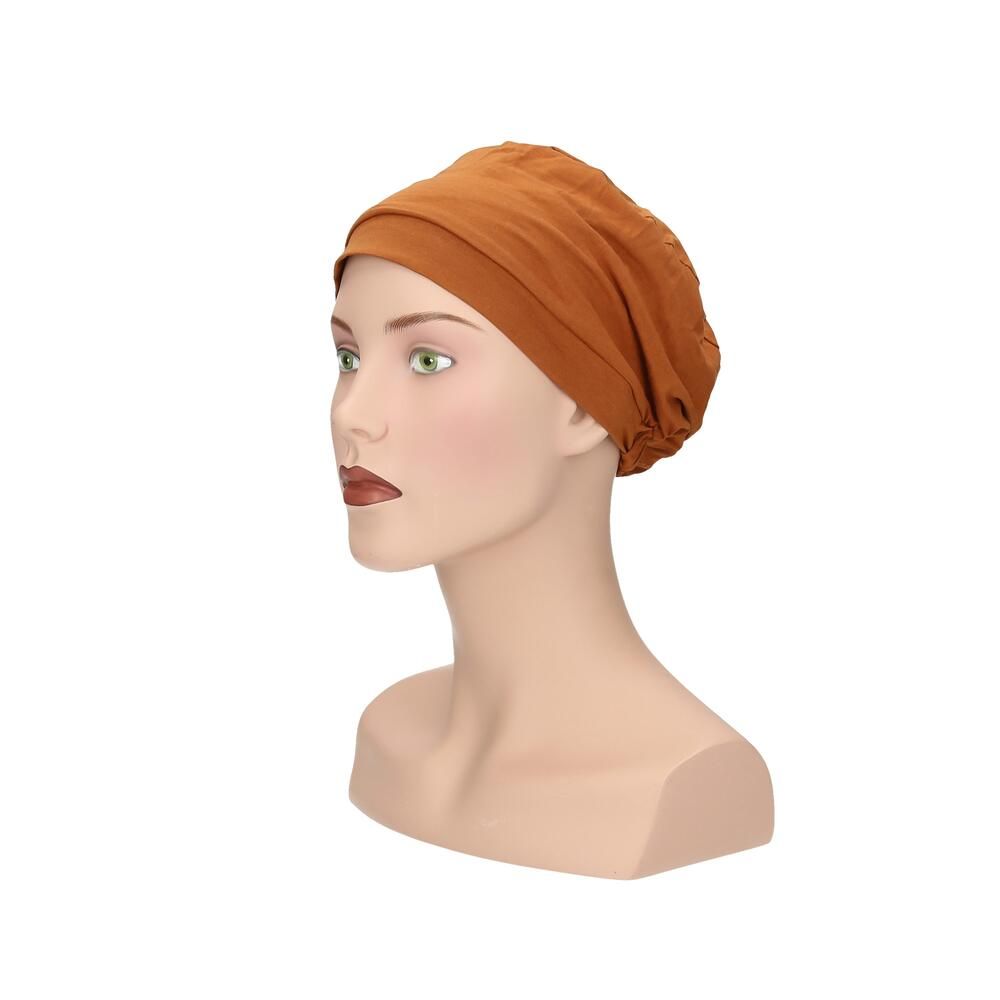 Ockerfarbener Turban auf einer Schaufensterpuppe. Seitenansicht. Stoff mit Falten. Für Kopfbedeckung.