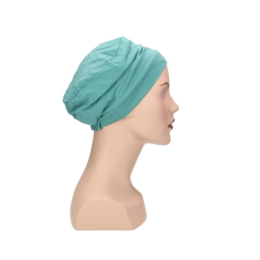 Türkisgrüner Turban auf einer Schaufensterpuppe. Der Turban bedeckt den Kopf. Seitenansicht.