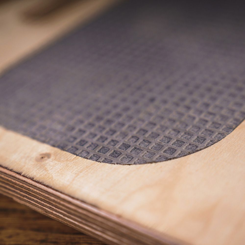 Nahaufnahme der perforierten Oberfläche der Movebox aus Holz. Die Oberfläche ist dunkelgrau.