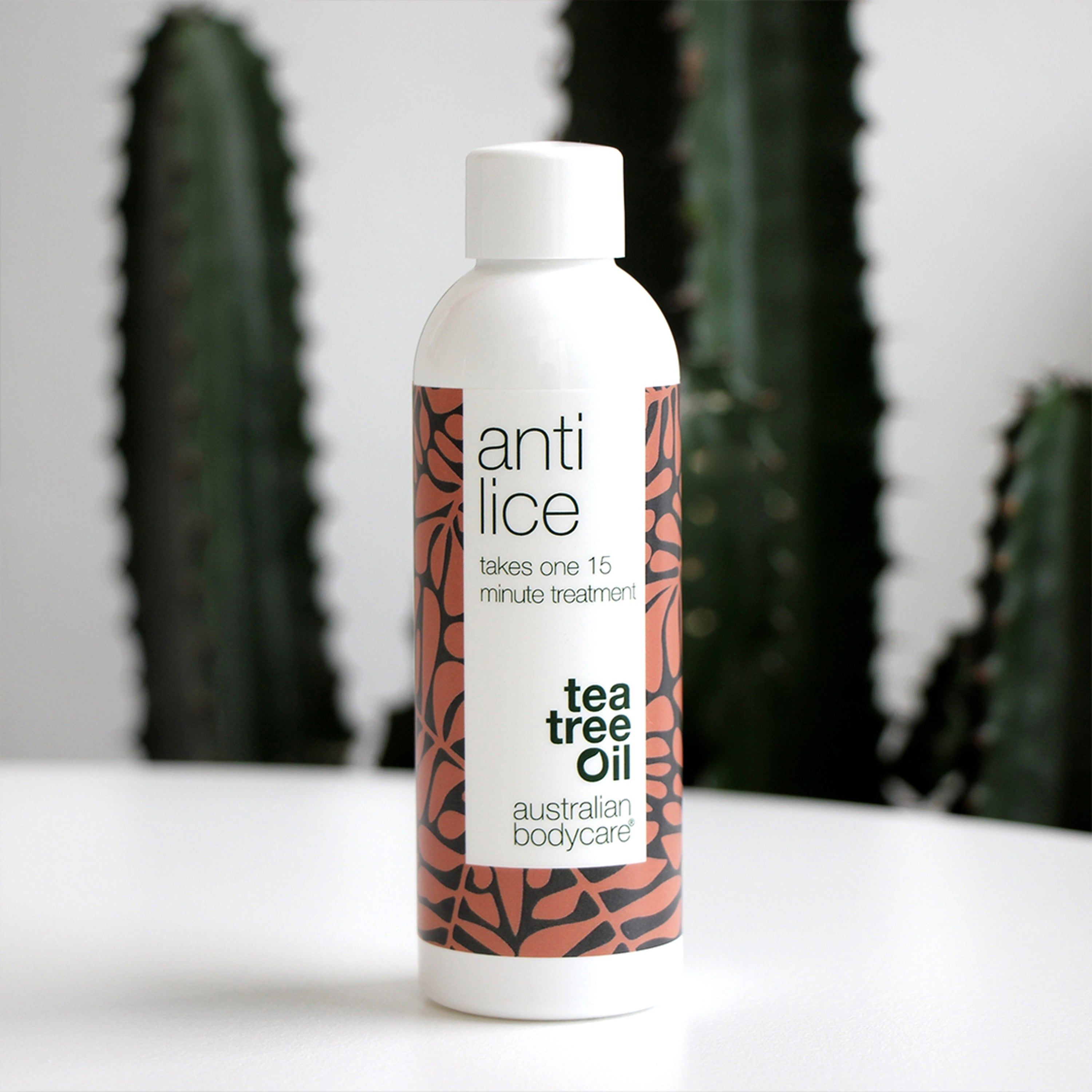 Weiße Flasche mit „Anti Lice“-Aufdruck. Braunes Muster. „Tea Tree Oil“ Aufdruck. Weißer Deckel.