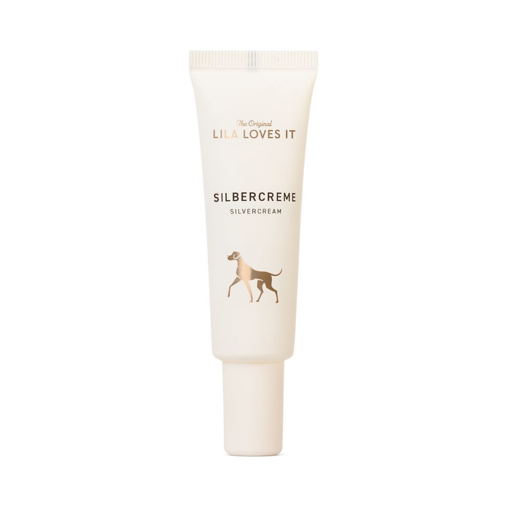 Creme-Tube mit Aufschrift "LILA LOVES IT" und "SILBERCREME". Abbildung eines Hundes. Weißer Hintergrund.