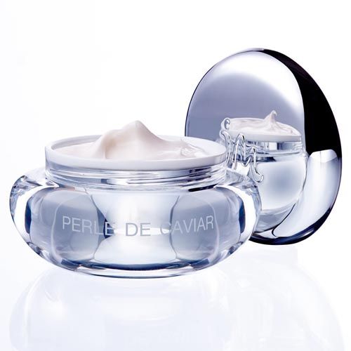 Creme in einem Glasbehälter mit Deckel. Aufschrift "Perle de Caviar". Reflektierender Hintergrund.