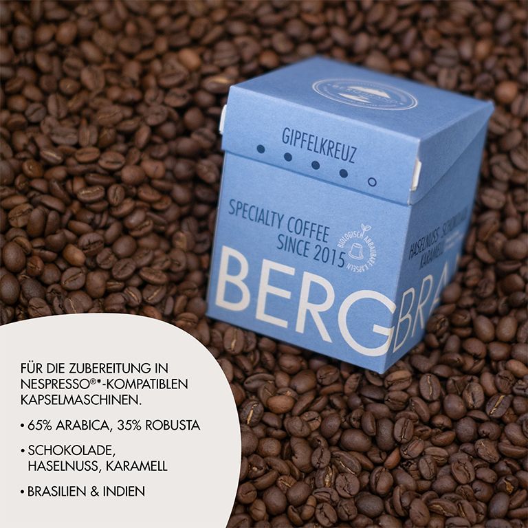 Blauer Karton mit BERGBRAND-Logo auf Kaffeebohnen. Text: Für Nespresso-kompatible Kapselmaschinen.