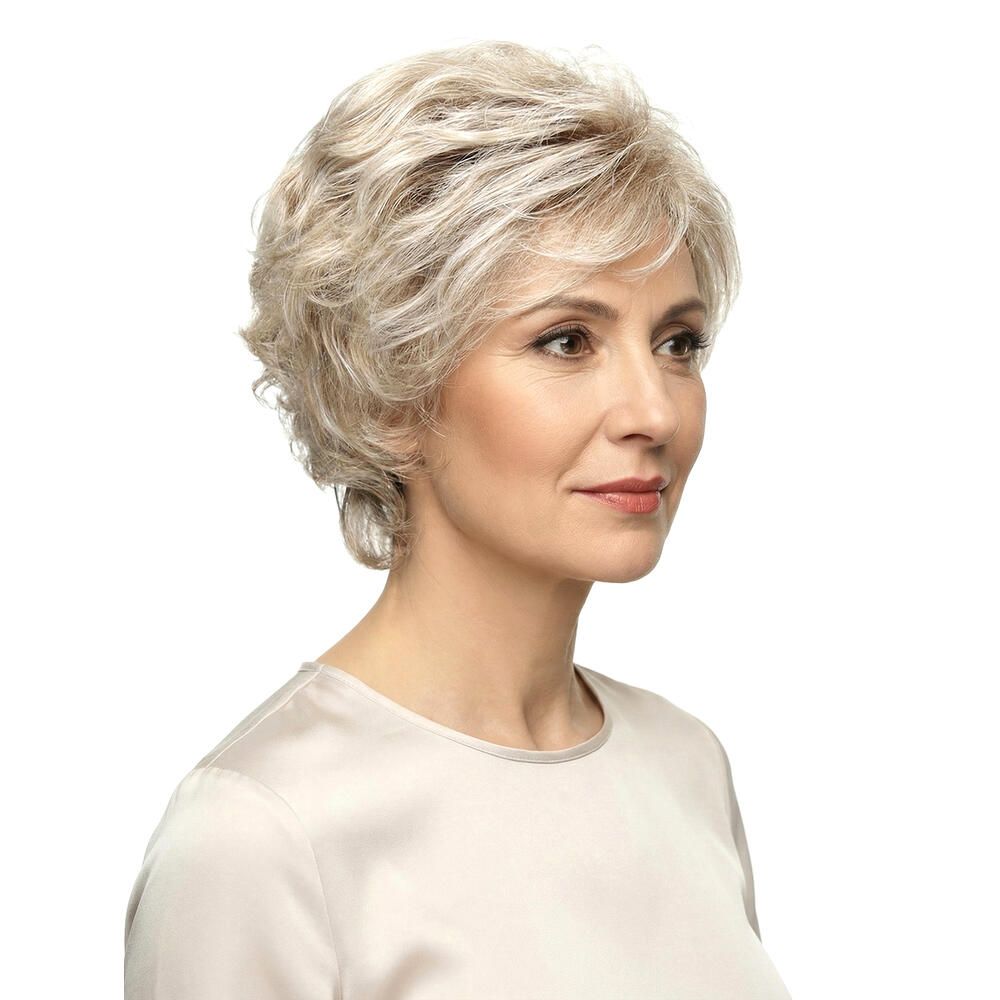 Frau mit kurzer, blond-grauer Perücke, Dreiviertelansicht. Helles Oberteil. Weißer Hintergrund.