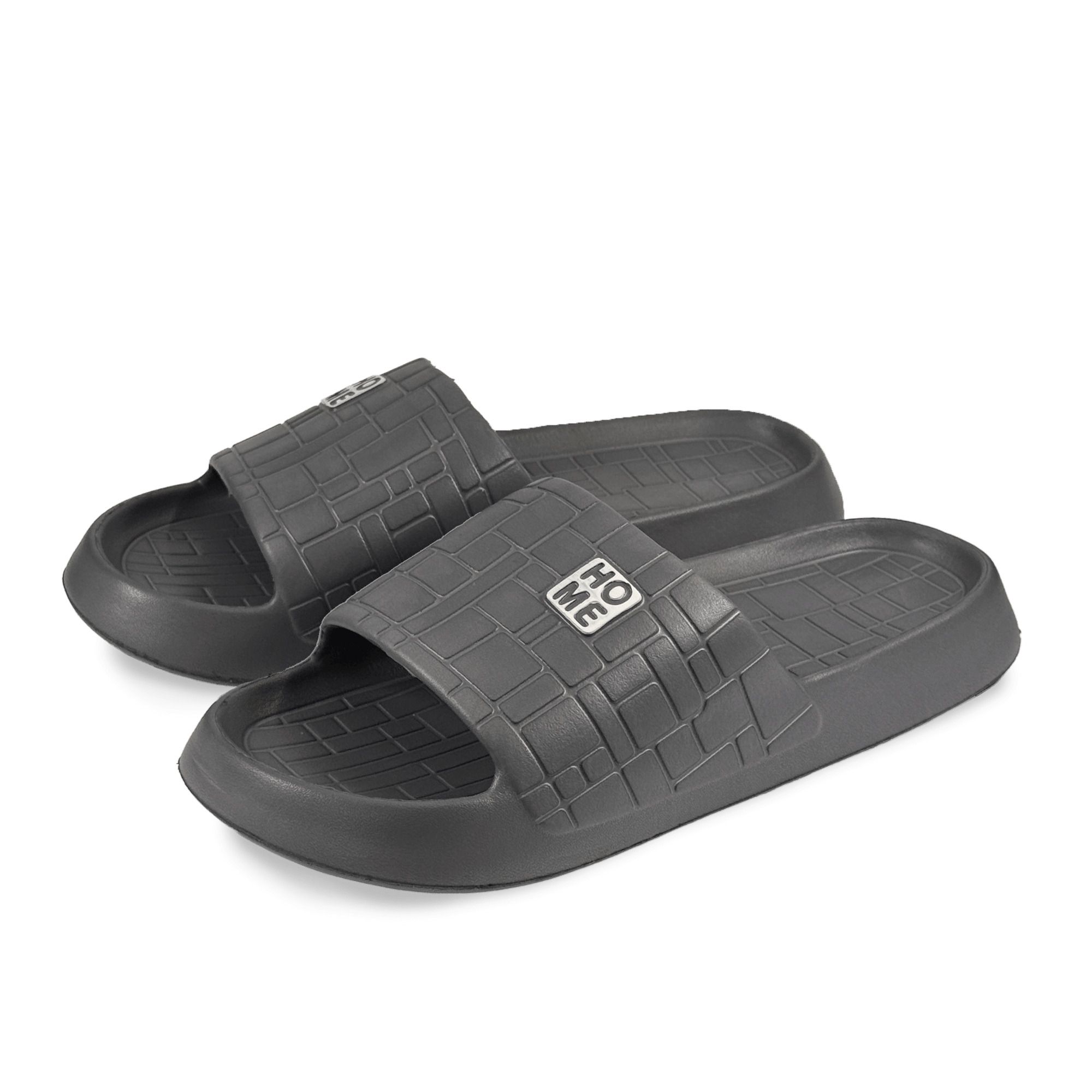Graue Pantoletten mit quadratischem Muster und "HOME"-Logo. Breite Form. Zwei Schuhe nebeneinander.