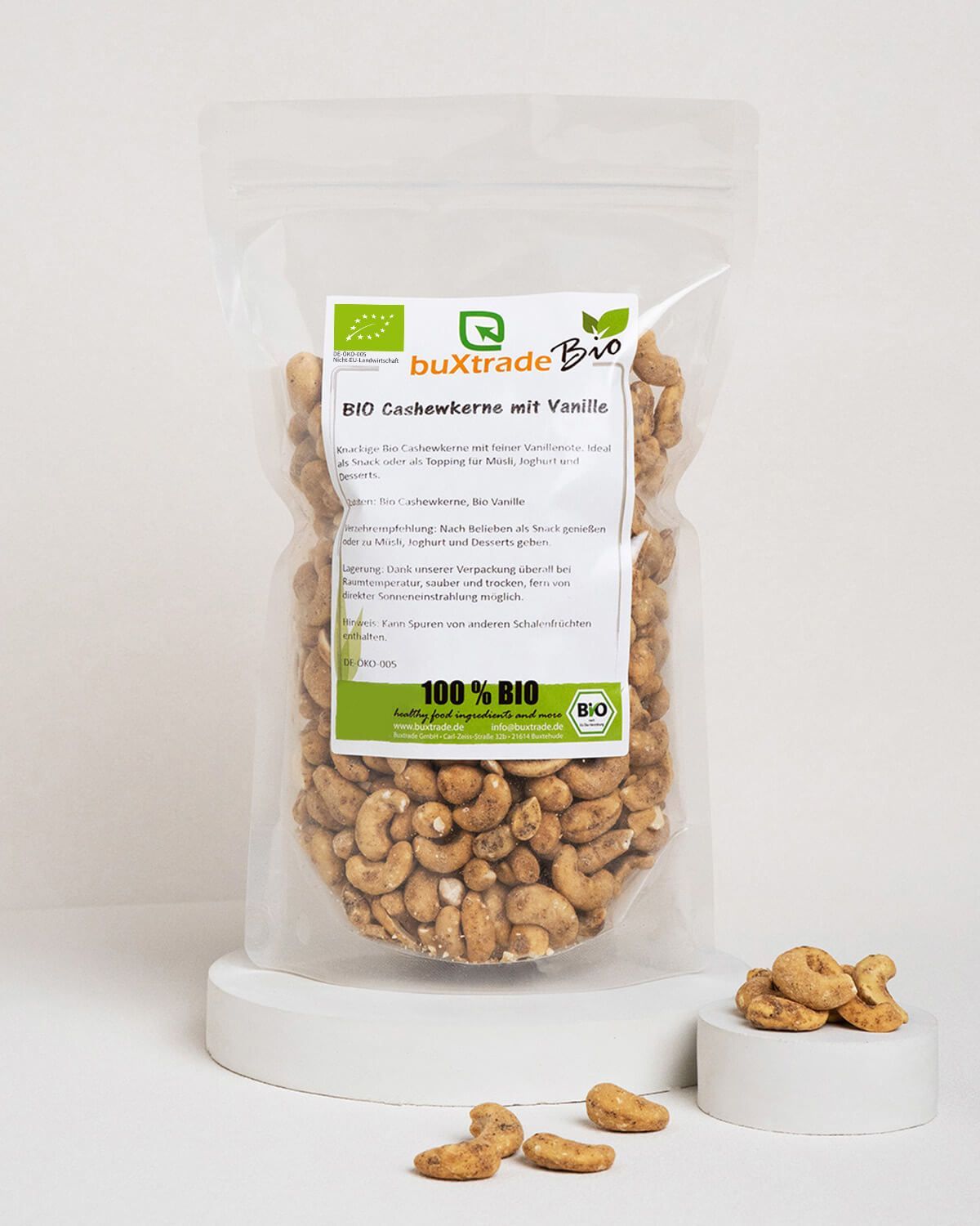 Bio Cashewkerne mit Vanille in transparenter Verpackung, einige Kerne liegen daneben.