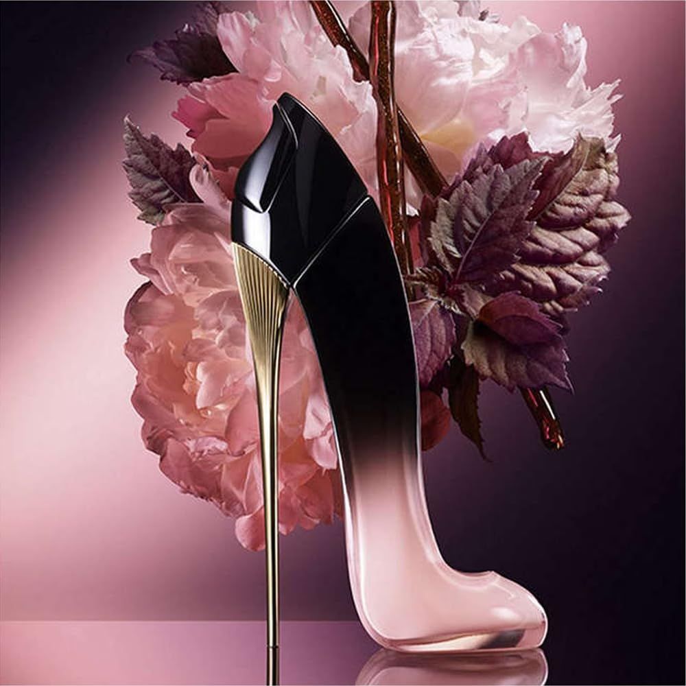 Schuhförmiger Flakon, schwarz-pink. Goldener Absatz. Mit Blüten und Blättern im Hintergrund.