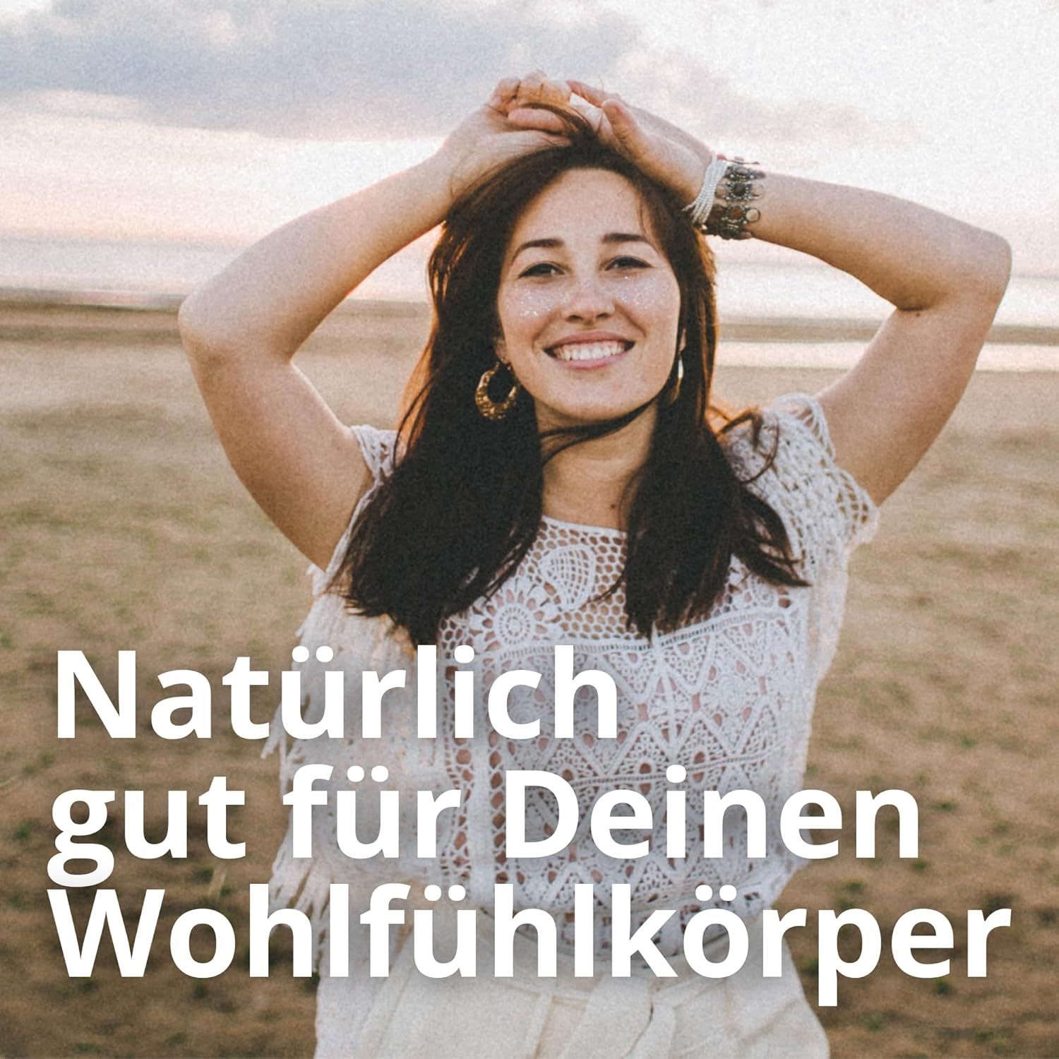 Eine lächelnde Frau mit erhobenen Armen am Strand. Text: Natürlich gut für Deinen Wohlfühlkörper.