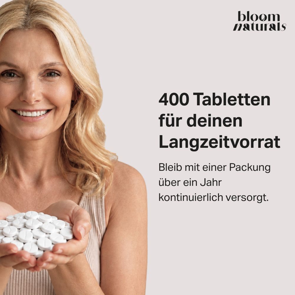 Frau hält Hände voll Vitamin B12 Tabletten. Text: 400 Tabletten für Langzeitvorrat.