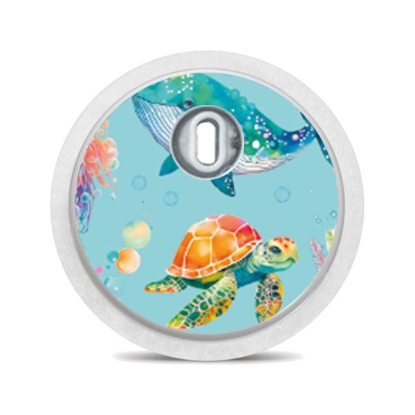 Runder Aufkleber mit Wal- und Schildkröten-Motiv. Aufkleber auf einem weißen Gerät.
