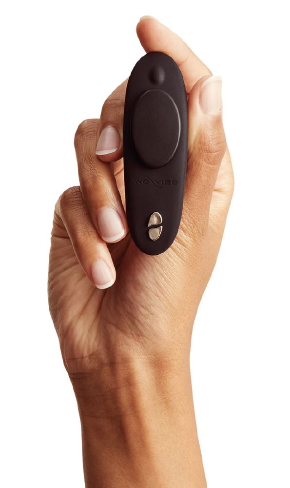 Hand hält ein schwarzes Vibrationsgerät. Das Gerät hat eine ovale Form mit einem runden Element und zwei Knöpfen.